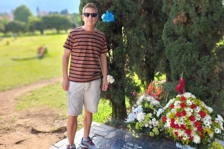 En person står ved et mindesmærke med blomster. 4