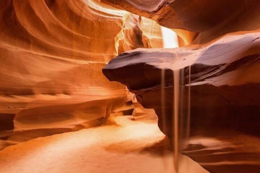 Un canyon stretto con pareti rocciose lisce e curve, e un ruscello che lo attraversa. 3