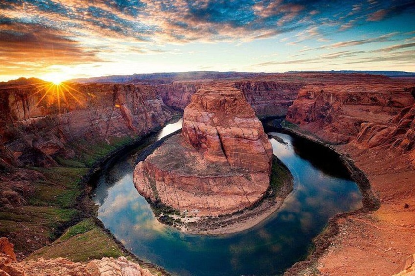 A canyon with a river, a large rock formation, and a sunset. 5