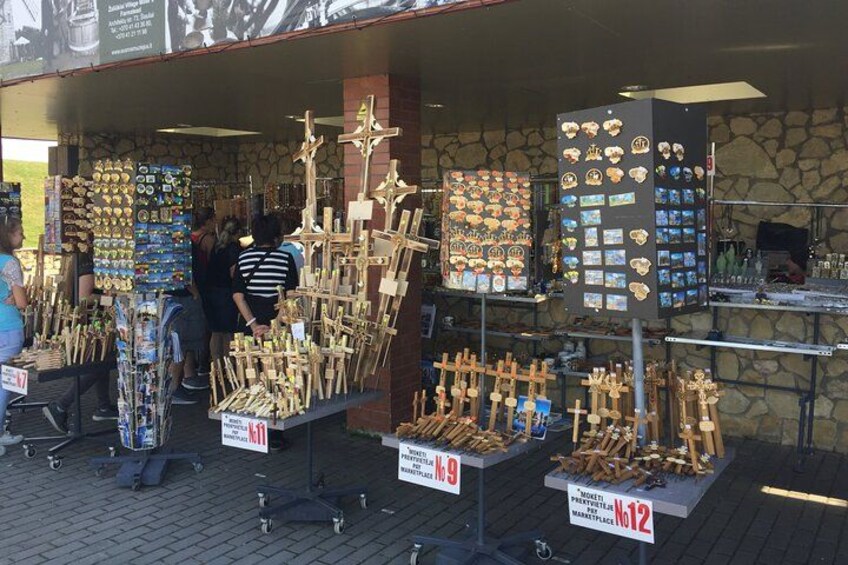 Un étal de marché où sont exposées des croix en bois et des objets religieux. 3