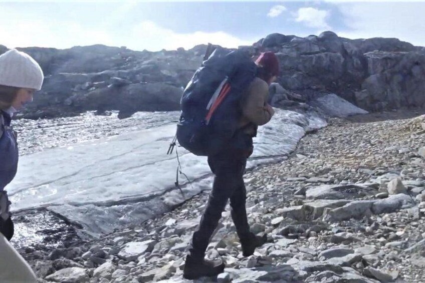 Eine Person wandert mit einem Rucksack über unwegsames Gelände. 4