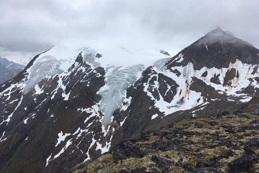 Ein Gletscher auf einem Berg mit Schneeflächen und felsigem Gelände. 5