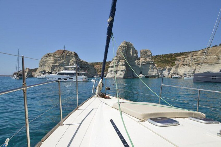 Un velero sobre aguas tranquilas, con acantilados rocosos al fondo. 5