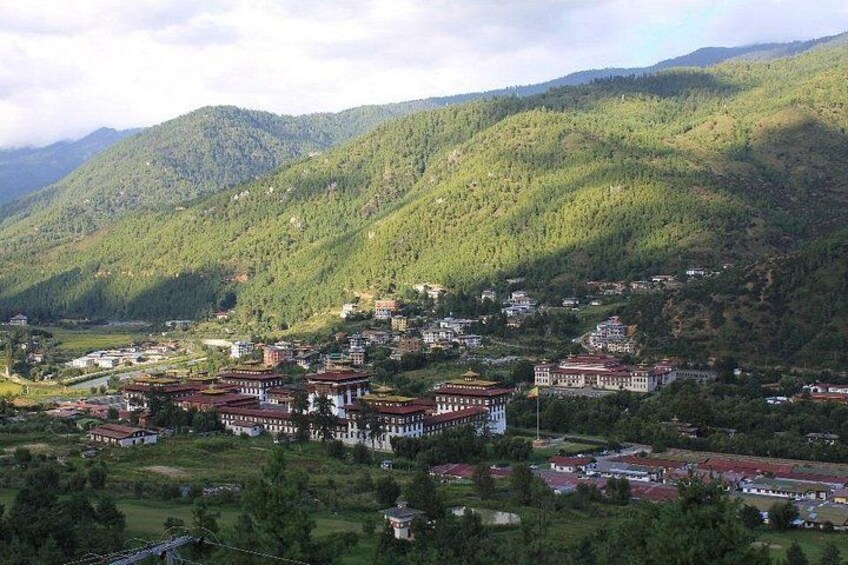 Un paysage montagneux parsemé d’un ensemble de bâtiments traditionnels, vraisemblablement un monastère, le tout entouré d’une végétation luxuriante. 5