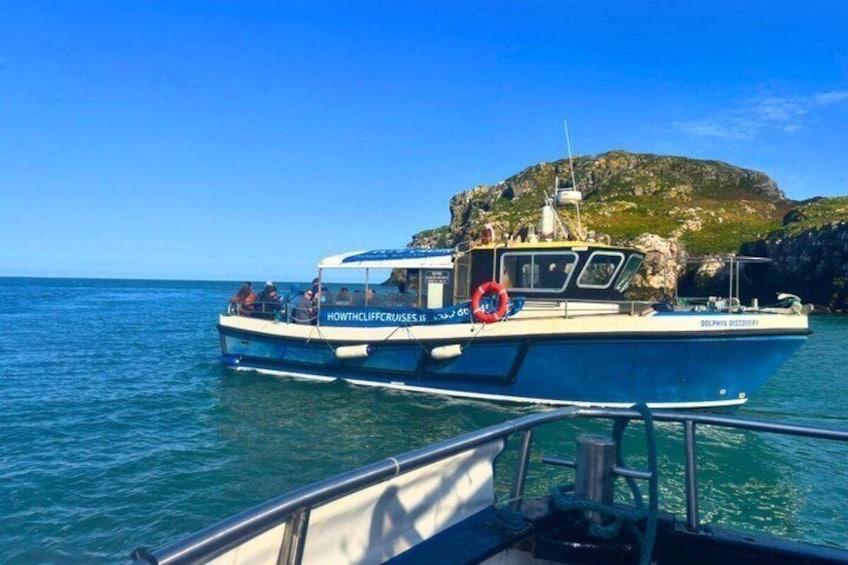 A boat named 'Howth Cliff Cruises' with a rocky island in the background. 5