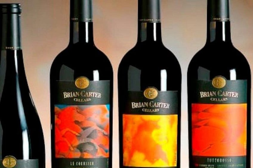 Four bottles of Brian Carter Cuvée wine with labels featuring abstract designs. 2