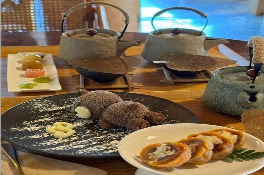 Et bord med chokoladedesserter, dampende dumplings og en tepotte. 3