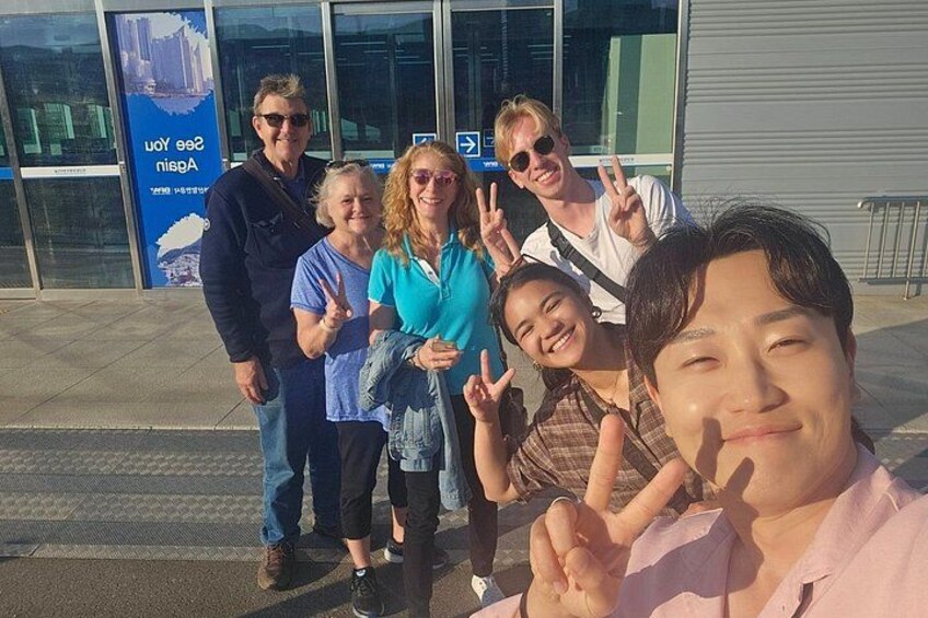 En gruppe mennesker poserer foran en bygning med et blåt skilt. 4