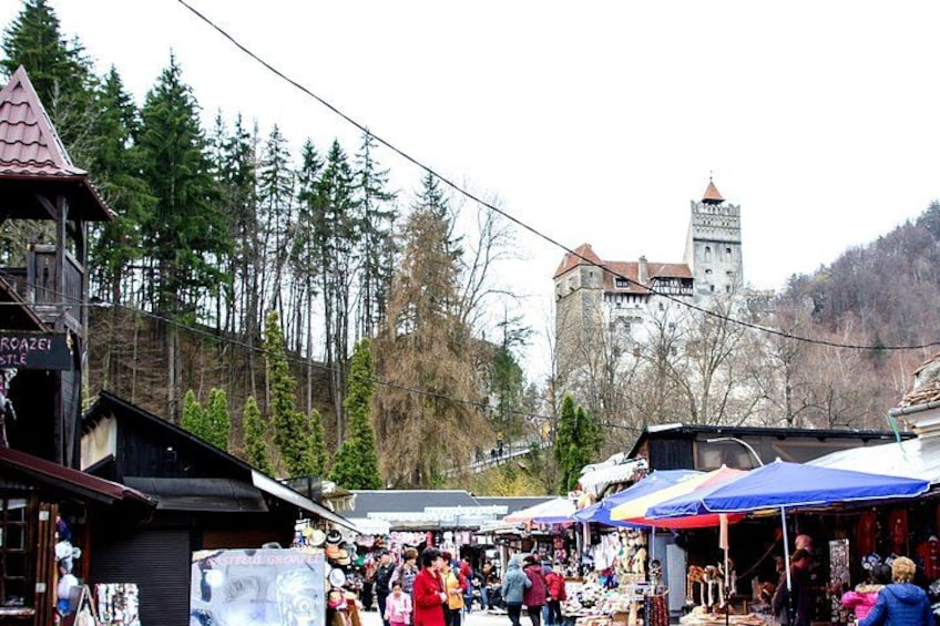 Un marché avec des étals et un château en arrière-plan. 4