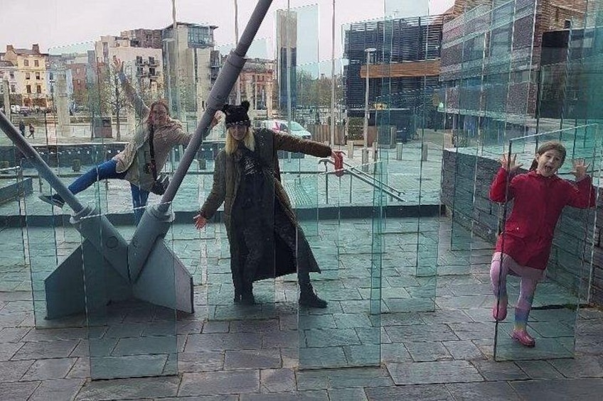 People interacting with a large, modern sculpture in an urban setting. 4