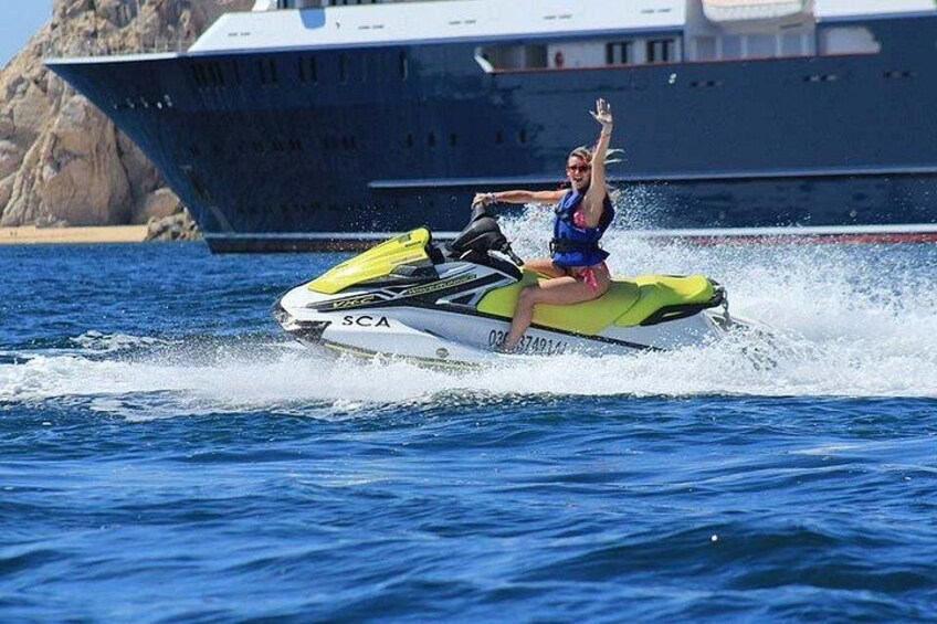 Una persona in jet ski su un corpo d'acqua, con una grande nave sullo sfondo. 2