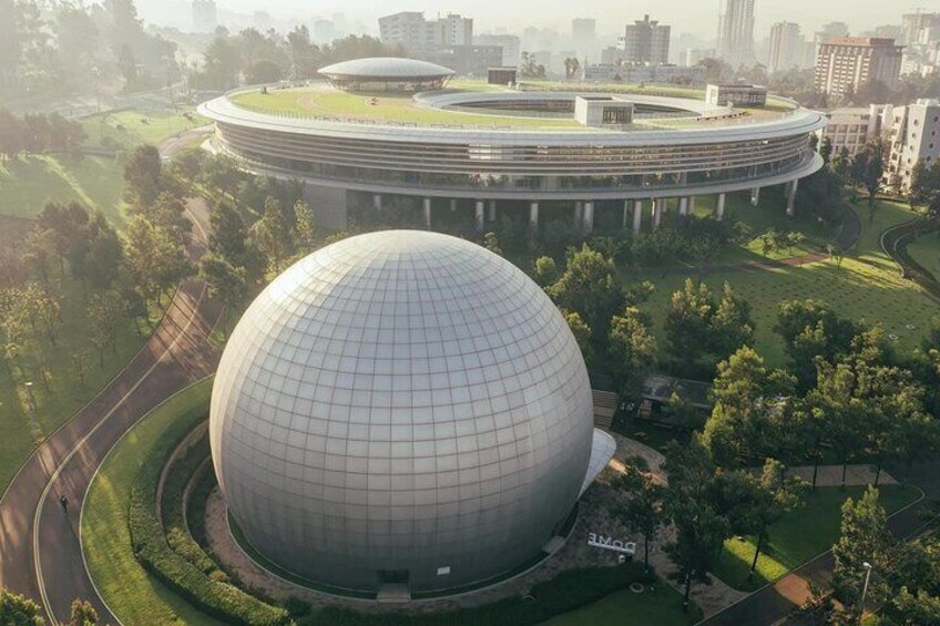 A large spherical building surrounded by greenery and a circular structure in the background. 5