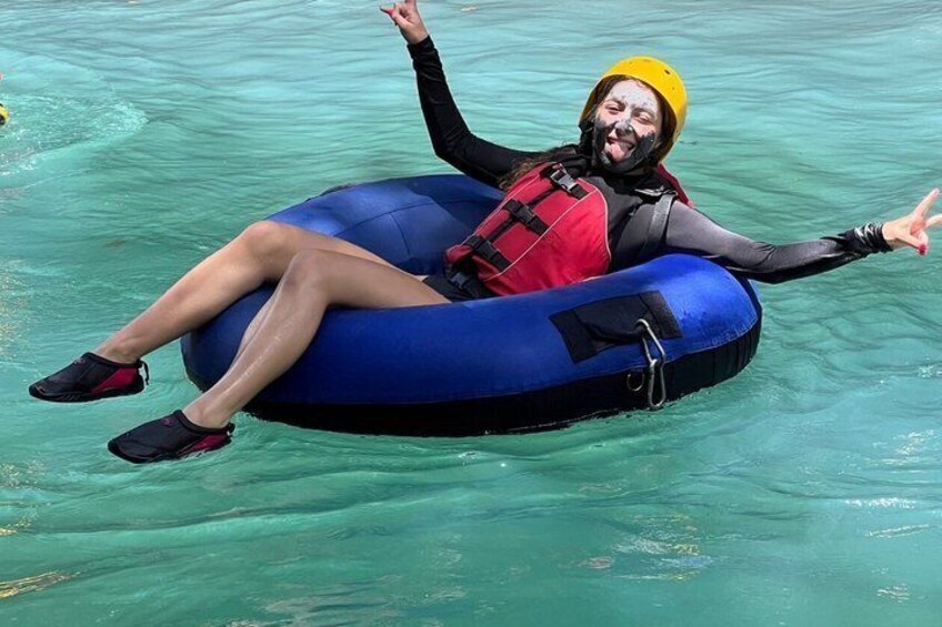Una persona flota sobre una balsa inflable azul en aguas cristalinas. 4
