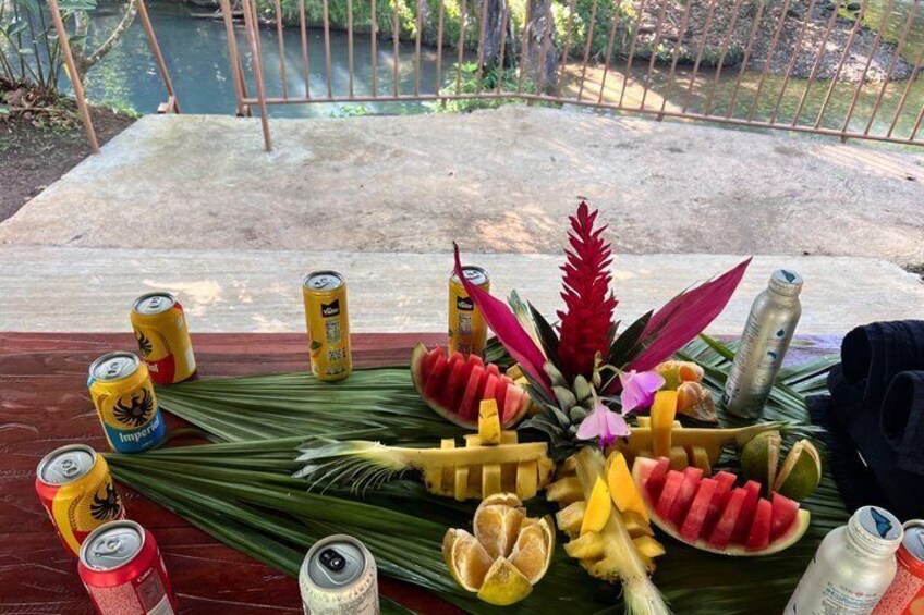 Una mesa con latas, frutas y un arreglo floral. 5