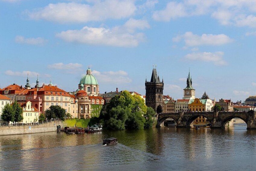 A river with a bridge, historic buildings, and a tower. 5