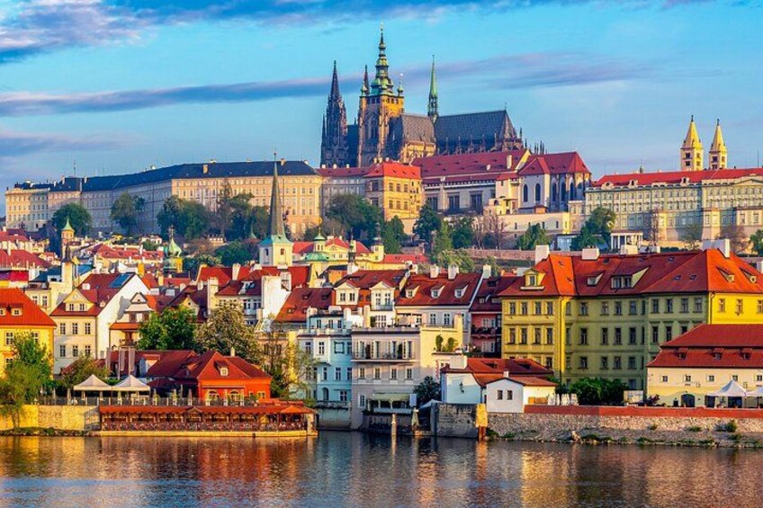 A cityscape with a prominent church spire, colorful buildings, and a river. 1