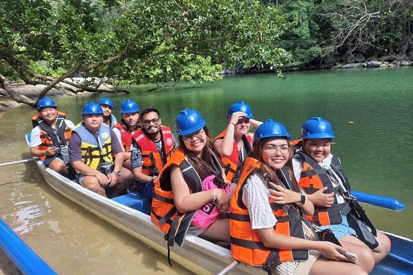 A group of people in a canoe on a river surrounded by greenery. 3