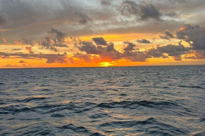 Een zonsondergang boven de oceaan met golven en wolken. 4