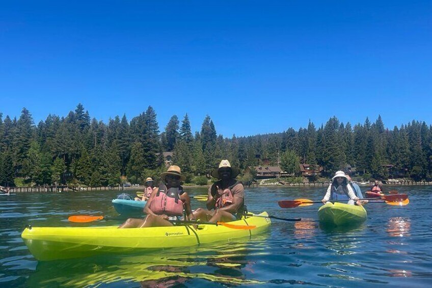 People kayaking on a lake with a forested shoreline. 2