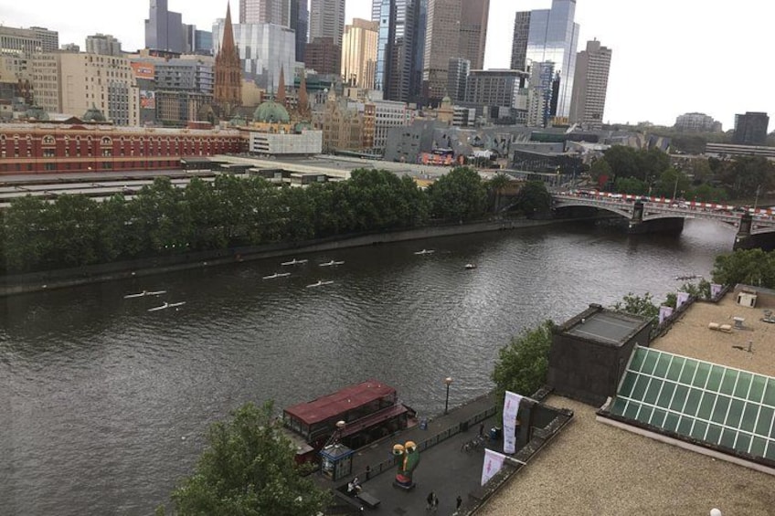 A river with a bridge, city buildings, and a small boat. 2
