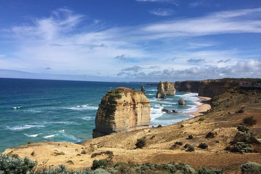 A coastal landscape with prominent rock formations and a sandy beach. 4