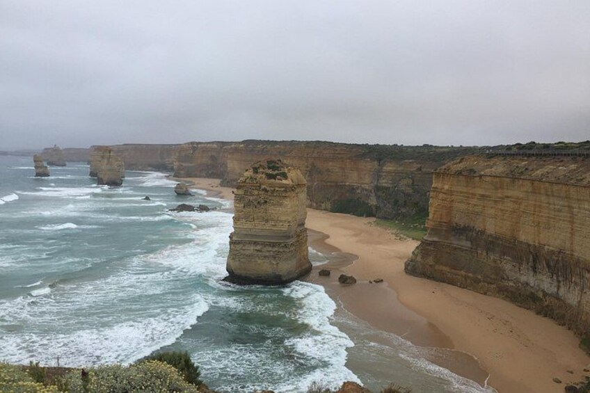 A coastal landscape with prominent rock formations and a sandy beach. 5
