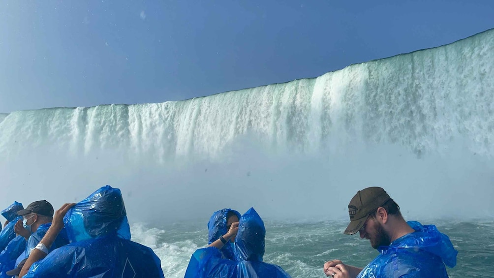 Un grupo de personas con equipo impermeable observando una cascada imponente. 1