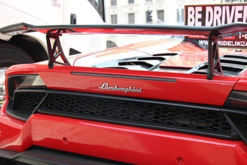 A red Lamborghini with a prominent rear spoiler and the word 'Lamborghini' on the front grille. 5