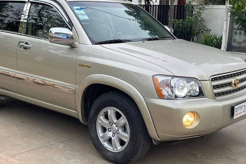 A beige SUV parked on a concrete surface. 1
