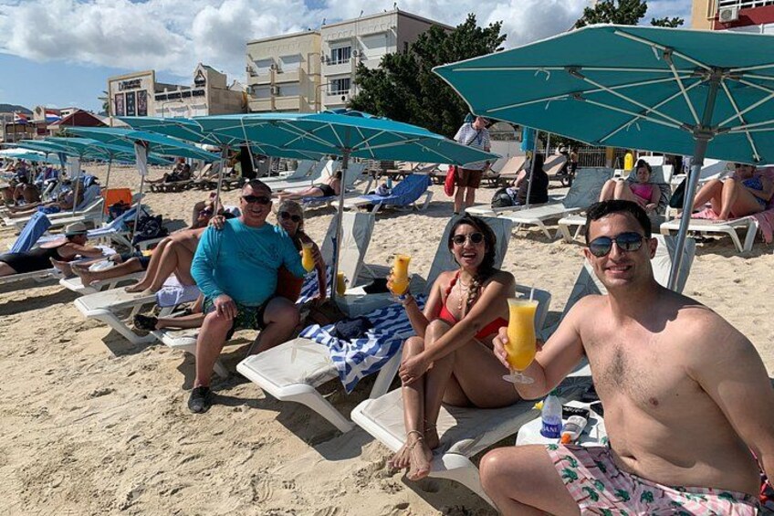 A beach with people relaxing on sun loungers under umbrellas. 2