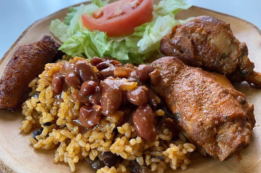 A plate of food with rice, beans, and fried chicken. 4