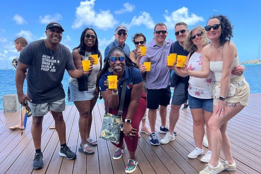 A group of people on a wooden deck by the water. 5