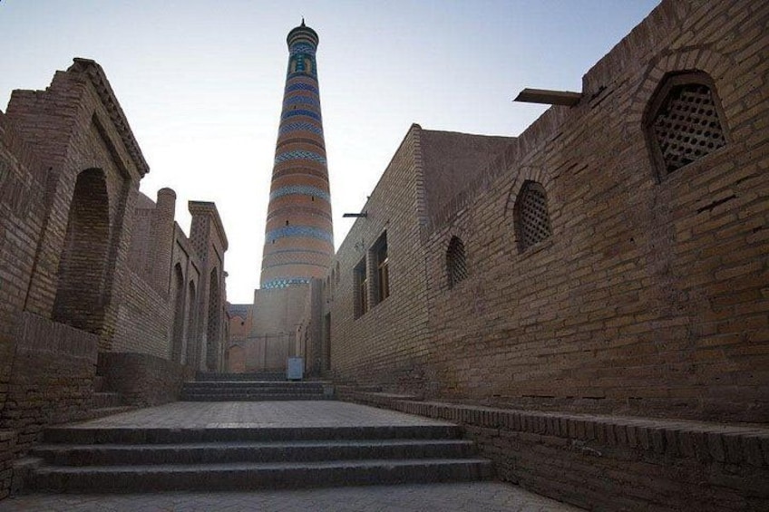 A historical building with a tall tower, brick walls, and a staircase leading to the tower. 5