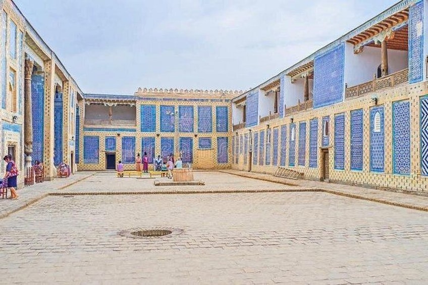 A courtyard with tiled walls and a central fountain. 2