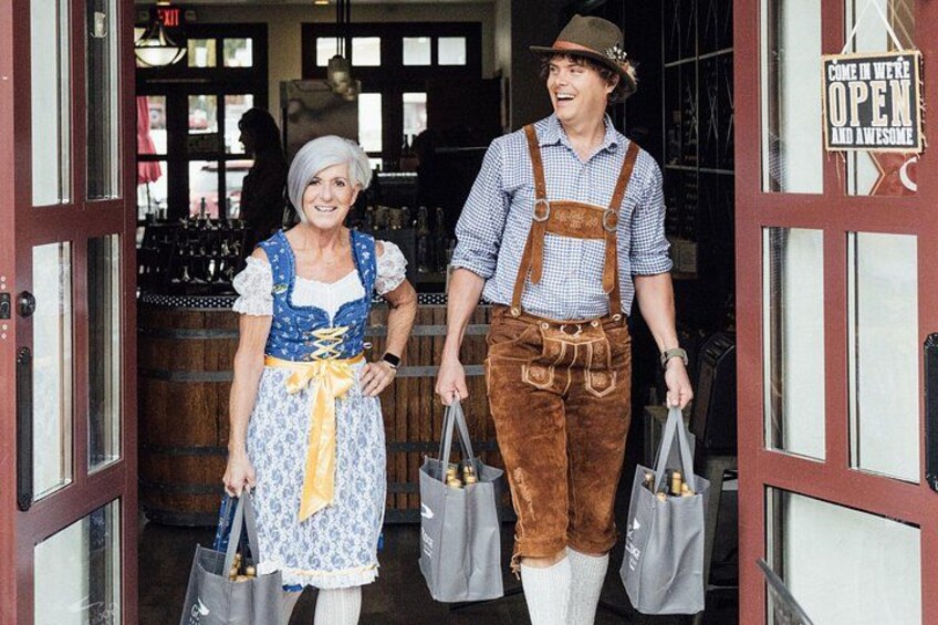 Zwei Personen in traditioneller Kleidung gehen durch einen Durchgang, an dem ein Schild steht: 'COME IN WE'RE OPEN AND AWESOME'. 3
