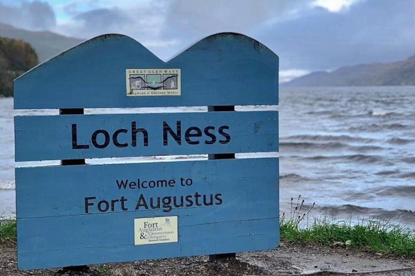 En blå skylt med texten ”Loch Ness” och ”Välkommen till Fort Augustus”. 1