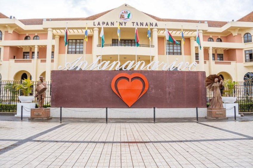 A building with a sign that reads 'Lapan'Ny Tanana' and 'Antananarivo' with a heart symbol. 1