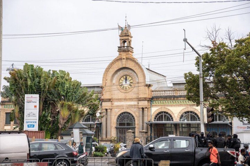 A historic building with a clock tower, surrounded by vehicles and pedestrians. 2