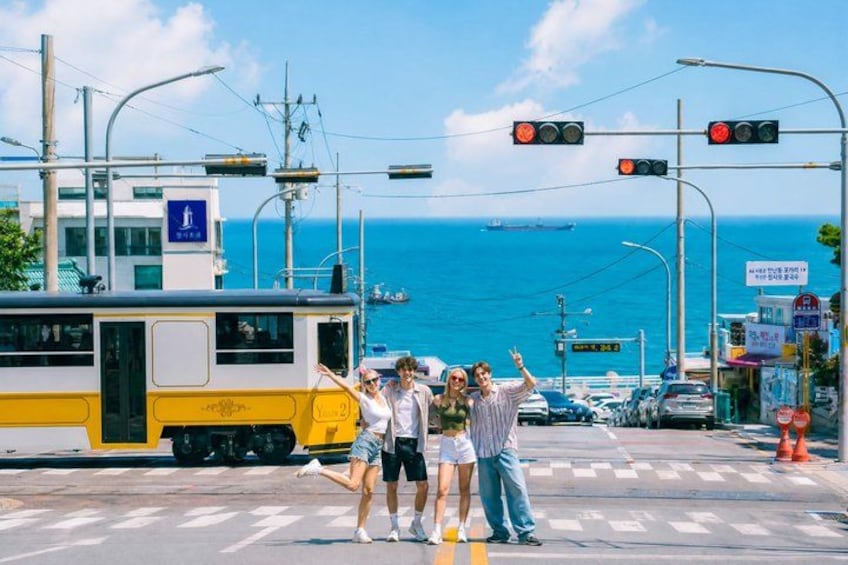 Un tramway à un carrefour près de la côte, d’où l’on a une vue dégagée sur la mer, et un passage piéton. 5