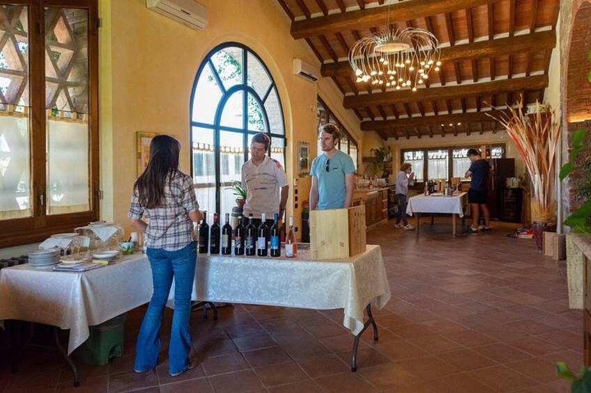 Degustación de vinos en un interior rústico con vigas de madera y un amplio ventanal de arco. 2