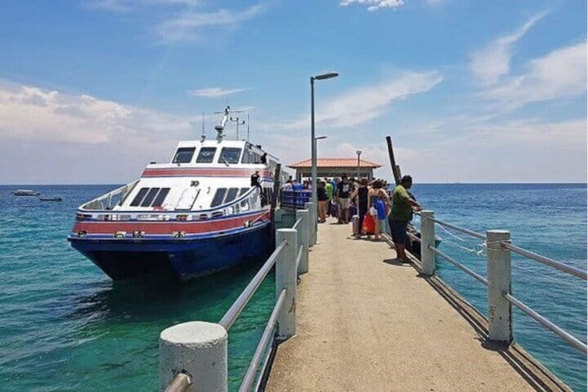 A pier with a boat docked, people on the pier, and the ocean in the background. 4
