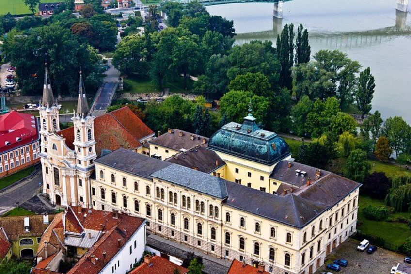 A historic building with a prominent tower, a large dome, and a river in the background. 4