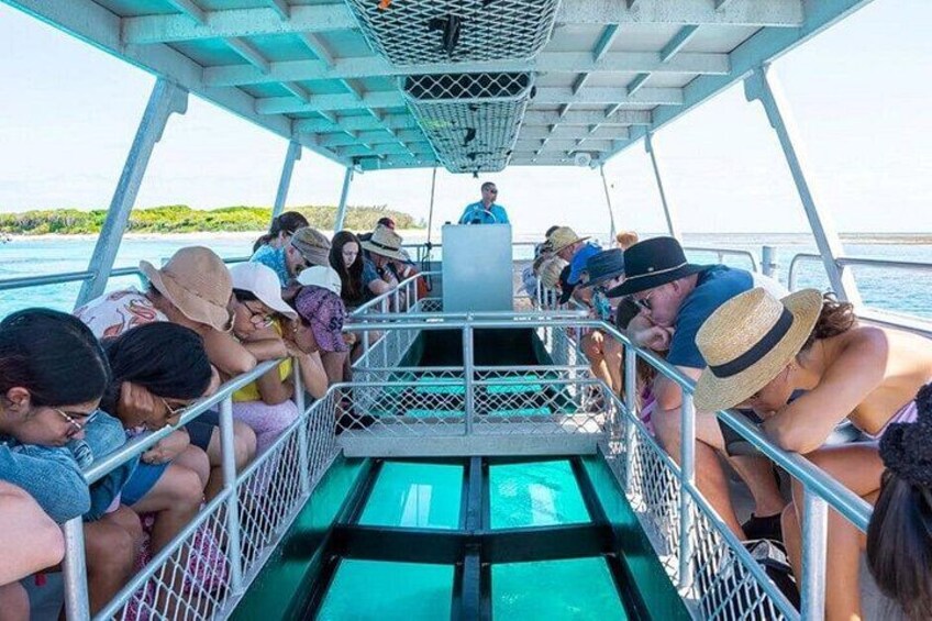 Un bateau avec des personnes assises sur le pont, une rambarde et une vue sur l’eau. 2