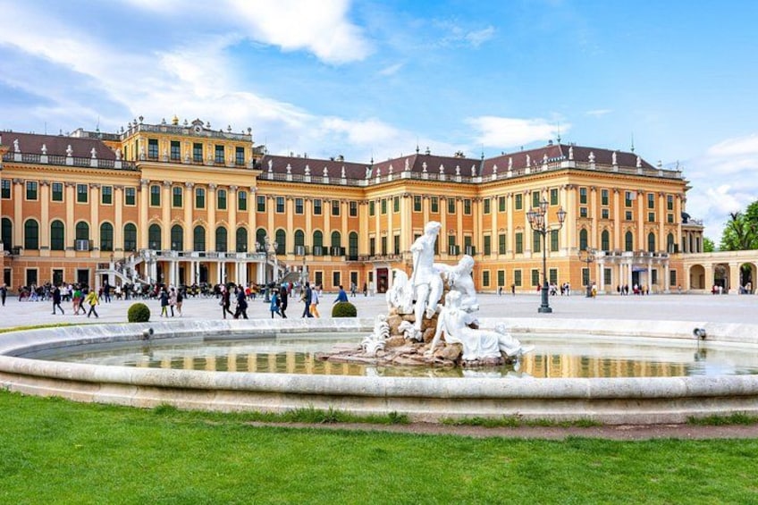 A large historic building with a fountain in front. 4
