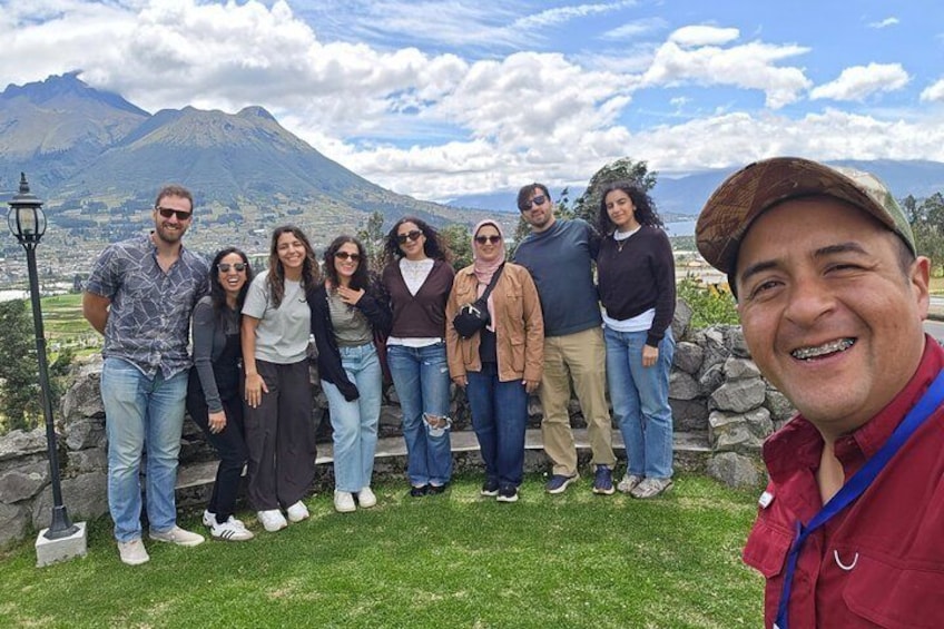 Un gruppo di persone in piedi su un'area erbosa, con una montagna sullo sfondo. 4