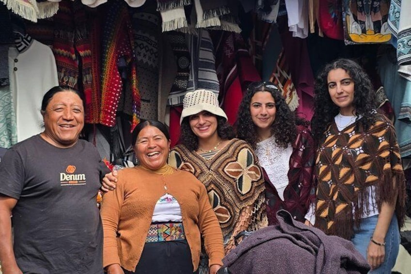 Un gruppo di persone in un mercato, tra tessuti colorati e abiti tradizionali. 3
