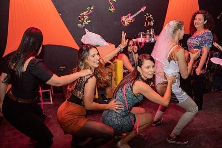 A group of people dancing in a room with orange walls and decorations. 4