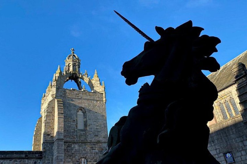 Eine historische Kirche mit einem markanten Glockenturm und einer Pferdestatue. 1