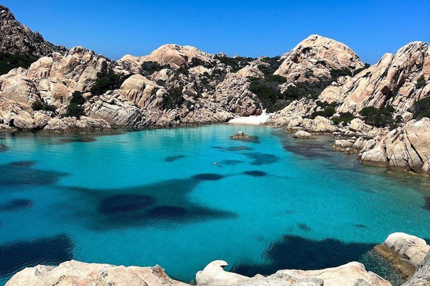 A turquoise sea surrounded by rocky cliffs. 4