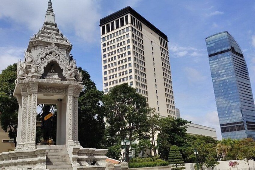 A traditional temple with intricate carvings, a modern high-rise building, and a sleek glass skyscraper. 3
